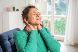 black woman suffering chronic neck pain.